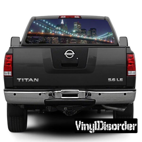 Black pickup truck rear with skyline bridge graphic rear window decal and red taillights
