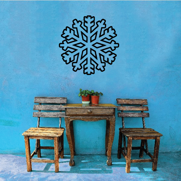 A set of snowflake decals displayed on a blue wall above a table and chairs