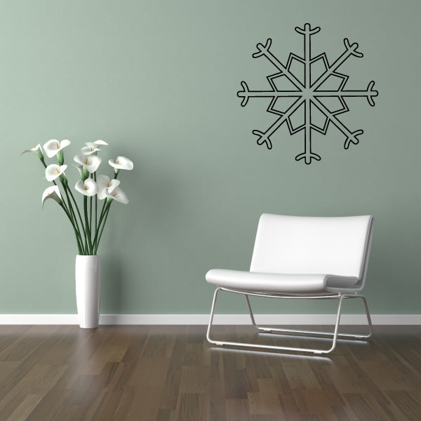 Elegant snowflake wall decal near a white chair and floral arrangement