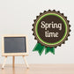 Spring time ribbon decal with circular badge and banner, brown and green with white lettering