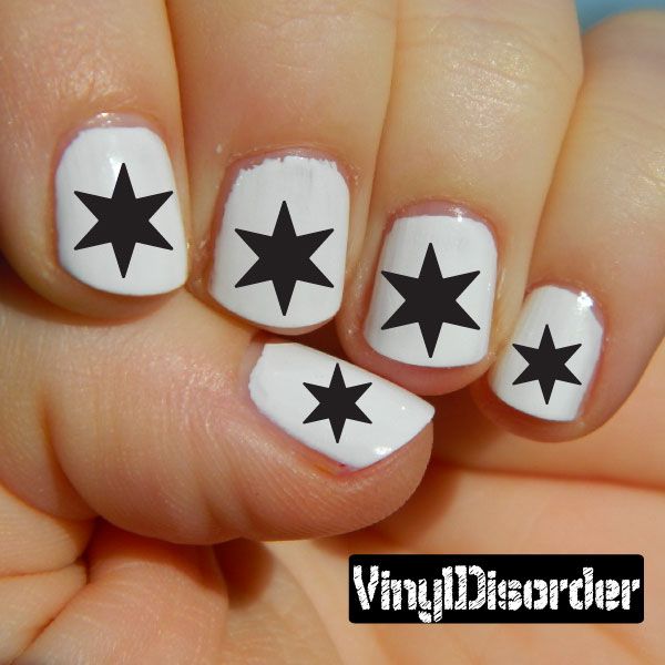 Nail art stickers with black star decals on white fingernails