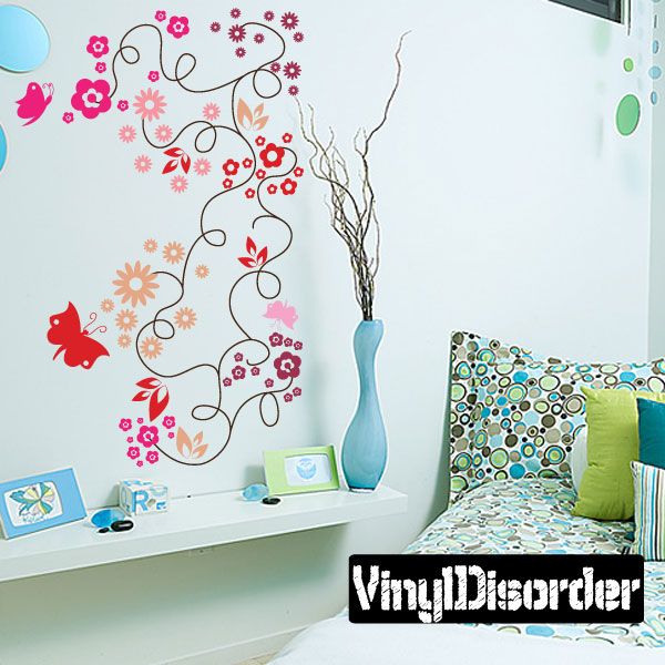 Wall decal of curling branch with flowers and butterflies, colorful pink and red accents