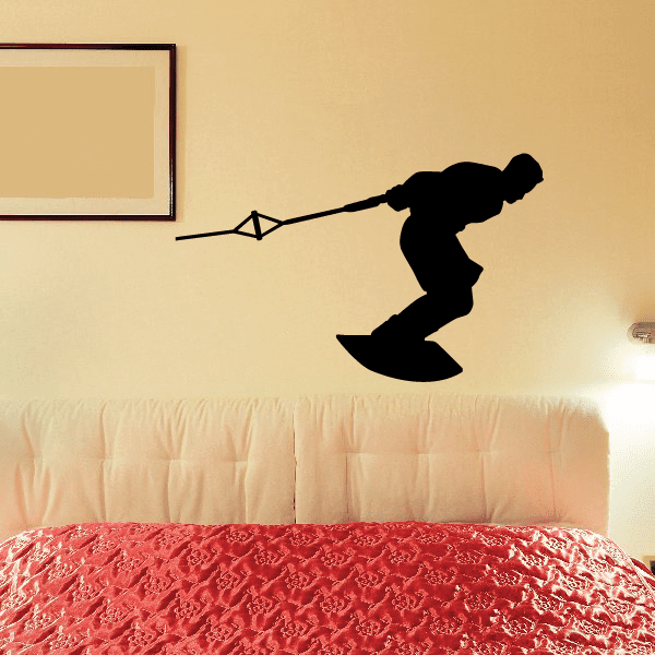 Black wakeboarding decal of a surfer holding rope, mid-air over a wakeboard.