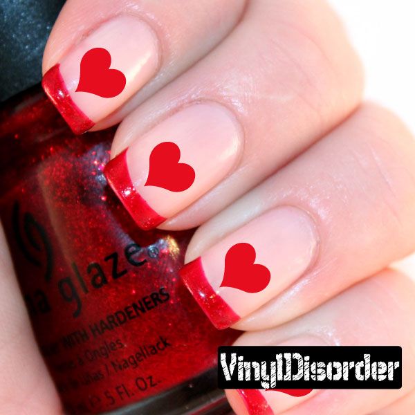Fingernail art sticker sheet with red heart nail decals on light nails
