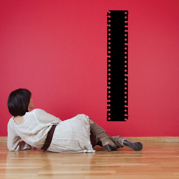 Black tattered film strip decal with perforated border and small red dot holes