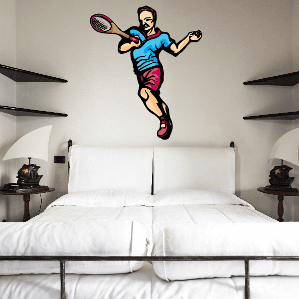Cartoon tennis wall decal of player mid-swing, blue shirt, pink shorts, tennis racket.