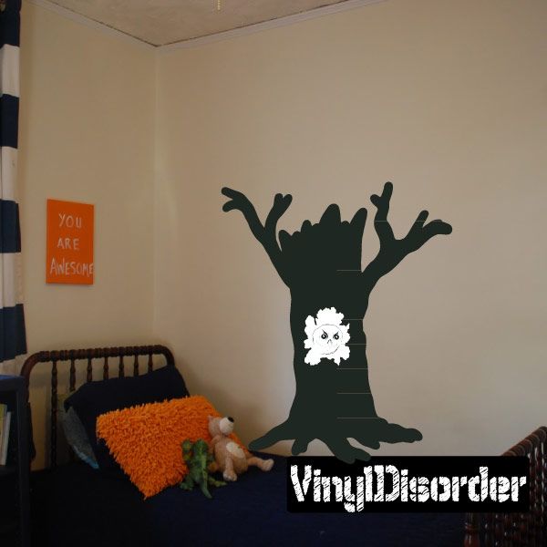Tree stump vinyl wall decal with dark silhouette and white creature face