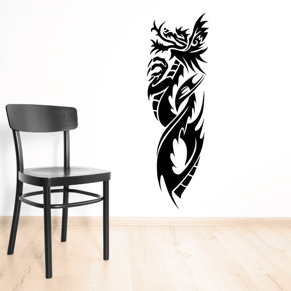 Black tribal dragon decal with flame-like head and scroll tail on wall