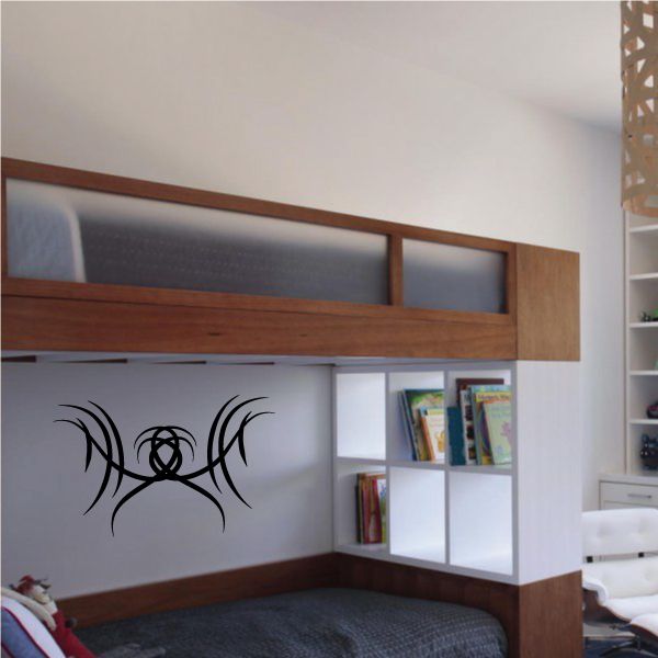 Tribal spider wall decal in black vinyl, curved legs and body on light wall