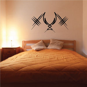 Tribal wall decal featuring central emblem with crossed line accents in dark ink