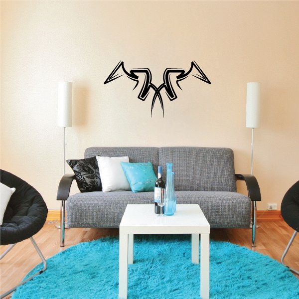 Black tribal pinstripe wall decal with two stylized arrows above couch.