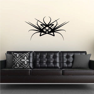 Tribal vinyl wall decal with black starburst and swirl lines above sofa