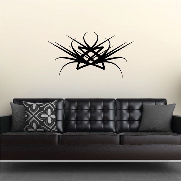 Tribal vinyl wall decal with black starburst and swirl lines above sofa