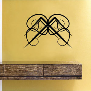 Black tribal wall decal with crossed dagger-like shapes and ribbon loops