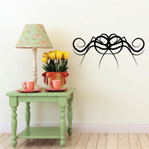 Ornate black floral scroll wall decal with curled vines and central flower