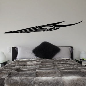 Tribal pinstripe vinyl decal, black swoosh with central emblem on wall