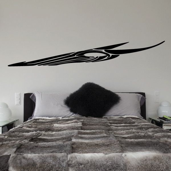 Tribal pinstripe vinyl decal, black swoosh with central emblem on wall