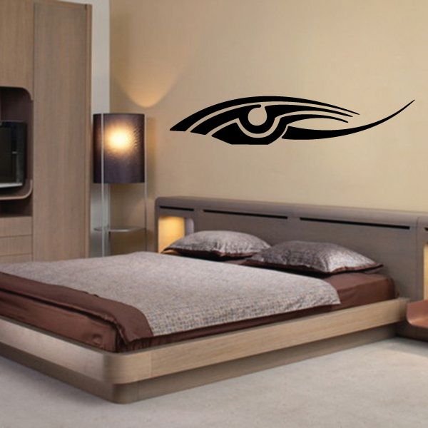 Tribal vehicle pinstripe vinyl decal with black eye-like symbol on wall