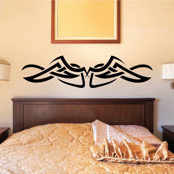 Tribal wall decal with black tribal knot design above a bed