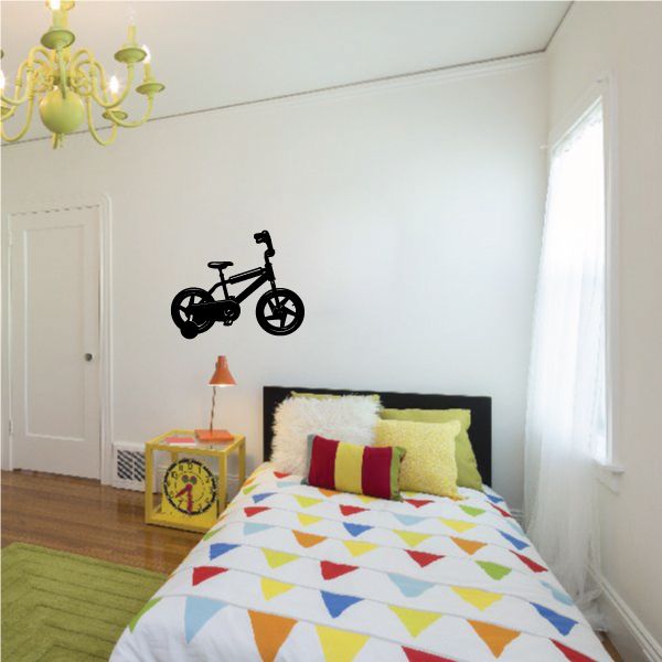 Black bicycle tricycle wall decal with rider silhouette, centered on wall