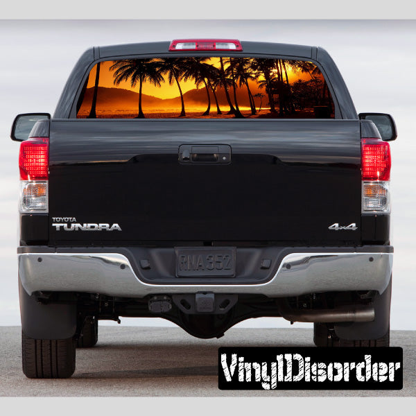 Pickup truck rear window with tropical palm sunset graphic
