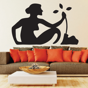 Black wall figure decal of a seated woman holding a curved bowl silhouette