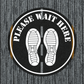 Round floor sticker with black background, white shoes, and 'Please Wait Here' text