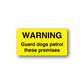 Yellow warning guard dogs patrol these premises sticker with black text
