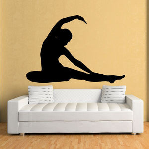 Yoga wall decal with black seated yoga silhouette on wall above couch