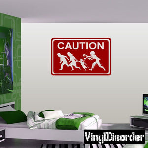 Caution sign vinyl decal with red border, white CAUTION text, and zombie silhouettes