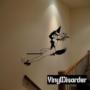 Black witch on broom wall decal, flying pose with hat and long hair