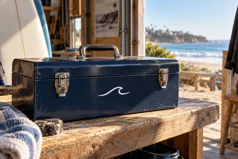 Coastal surf-workshop scene with a cut-vinyl wave on a metal toolbox