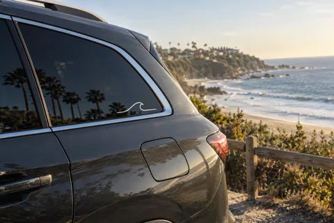 Dana Point-inspired beach scene with a cut-vinyl wave on a vehicle window