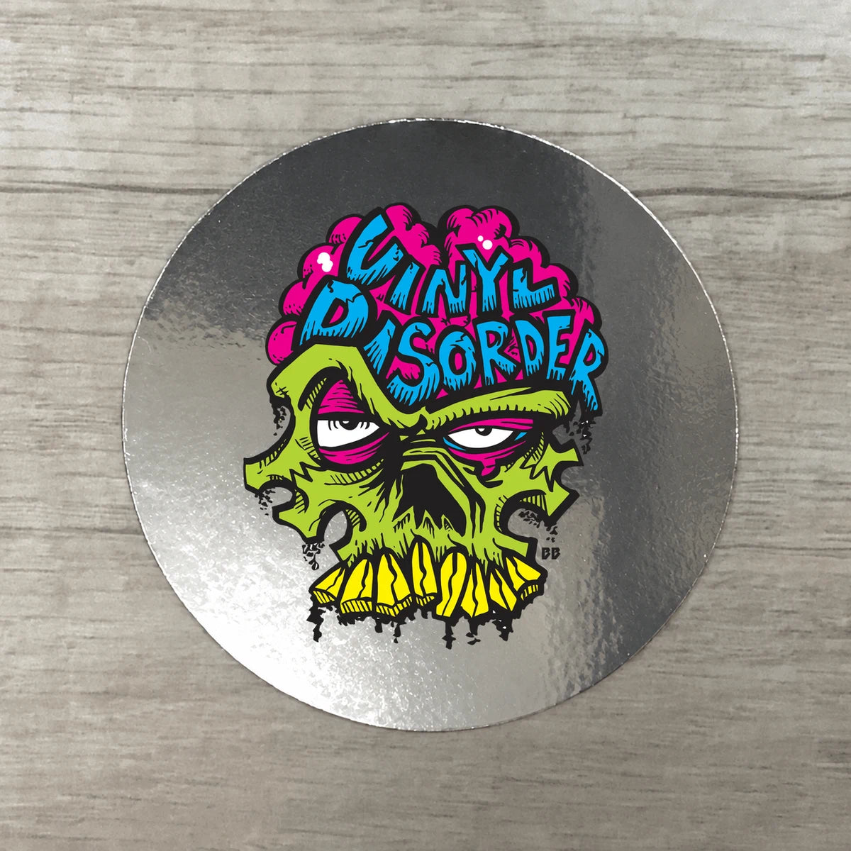 Silver chrome circular sample with authentic Vinyl Disorder skull artwork and exposed reflective border.